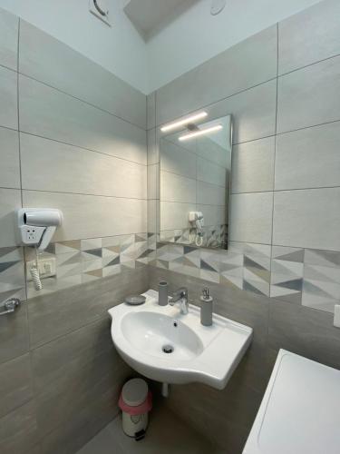 a white bathroom with a sink and a mirror at Seaway Accommodation " Private Parking " in Tropea