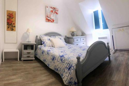 une chambre avec un lit avec une couette bleue et blanche dans l'établissement Maison accueillante en Normandie, à Montivilliers
