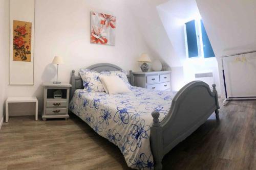 1 dormitorio con 1 cama con edredón azul y blanco en Maison accueillante en Normandie, en Montivilliers