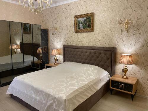 a bedroom with a bed and two lamps and a mirror at Museum Boutique Luxury GH in Sheki