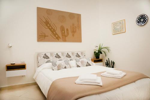 Un dormitorio con una gran cama blanca con toallas. en House Domusella, en Roma