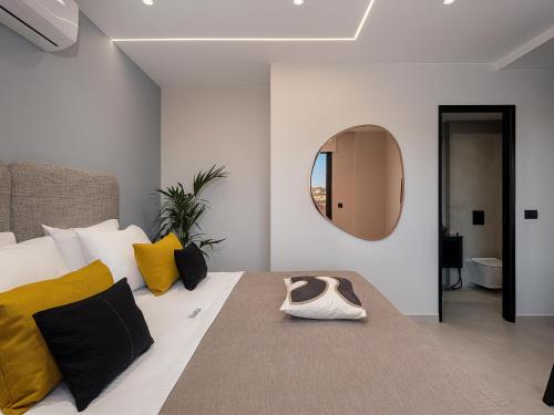 a bedroom with a bed with yellow pillows and a mirror at Theta Boutique Hotel in Chania