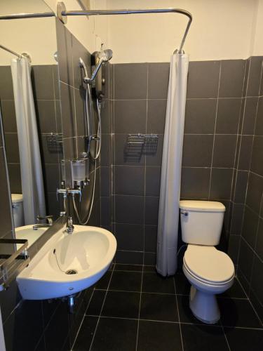 a bathroom with a toilet and a sink and a shower at The Old City Rooms in Chiang Mai