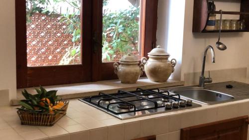 un bancone della cucina con piano cottura e 2 teiere di Villa Strazzeri a Palermo