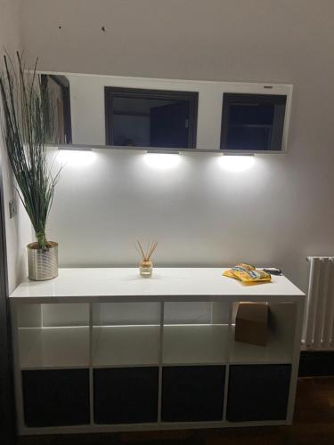 Un mostrador blanco con dos luces y una planta. en Cube Apartments, en Lytham St Annes