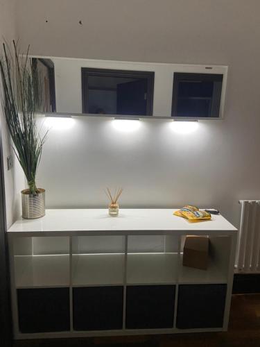 a white counter with two lights and a plant on it at Cube Apartments in Lytham St Annes