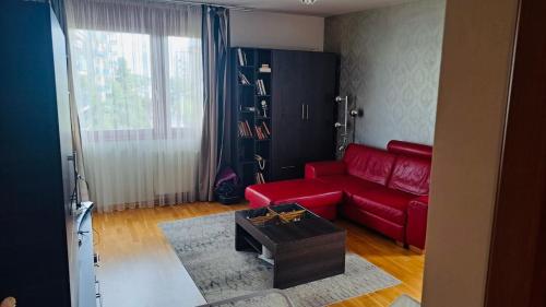 a living room with a red couch and a coffee table at Marina free parking in Budapest
