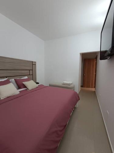a bedroom with a large bed and a flat screen tv at Margarita & More, Omas in Porlamar