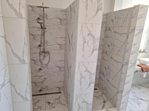 a bathroom with white marble walls and a shower at Laguna ubytovanie 2 B in Nemšová