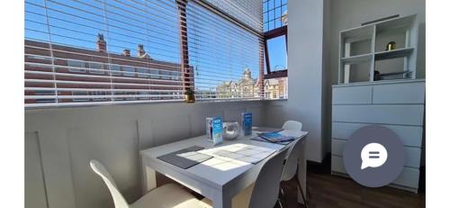 una mesa y sillas blancas en una habitación con ventana en Cube Apartments, en Lytham St Annes