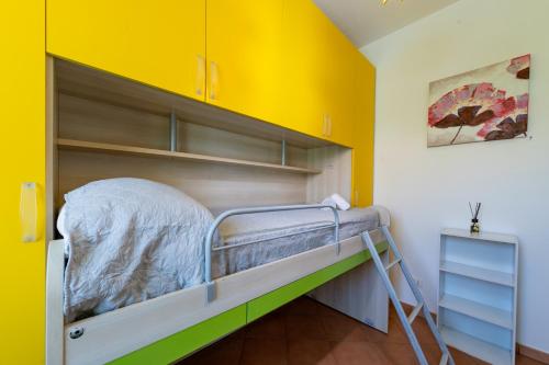 Łóżko piętrowe w pokoju z żółtą ścianą w obiekcie Villa Elena w mieście Campofelice di Roccella