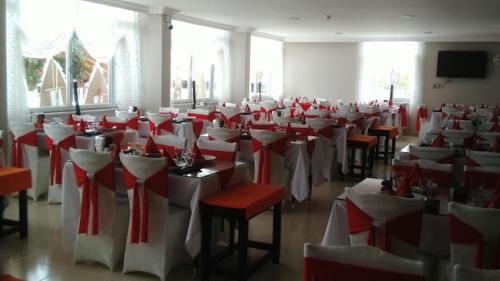 een kamer gevuld met rode en witte tafels en stoelen bij Gürsoy Kampüs Otel in Beysehir