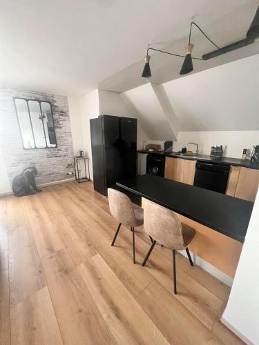 - une cuisine avec une table et des chaises noires dans la chambre dans l'établissement Duplex Ophélie, à Saint-Denis