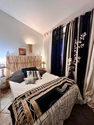 une chambre avec un lit avec une couverture noire et blanche dans l'établissement les pivoines, à Borgo