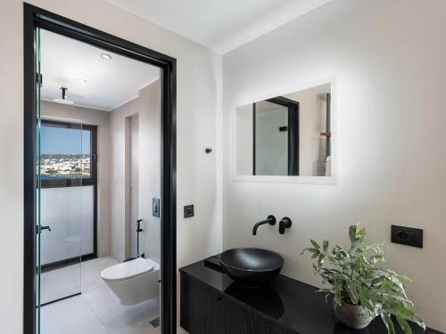 a bathroom with a sink and a toilet and a mirror at Theta Boutique Hotel in Chania