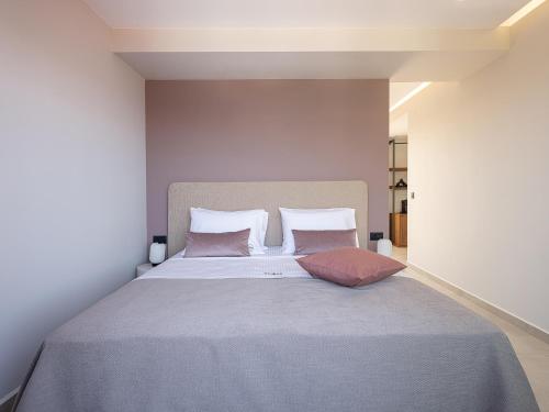 a bedroom with a large bed with two pillows at Theta Boutique Hotel in Chania