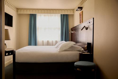 a hotel room with a bed and a window at Grand Hotel Bellevue London in London