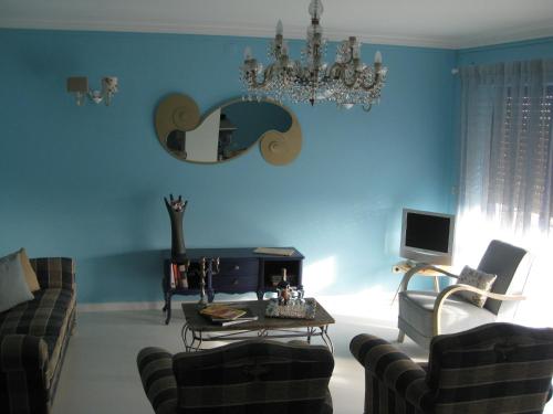 a living room with blue walls and a chandelier at Villa Spozendus in Esposende