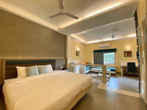a bedroom with a large bed and a living room at Status Club Resort in Kānpur
