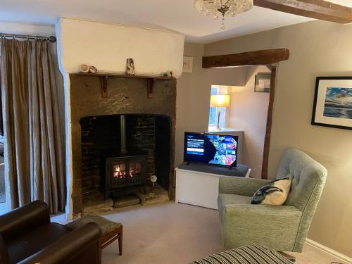 a living room with a fireplace and a tv at The Therapy Rooms Holmfirth Holiday Let in Holmfirth
