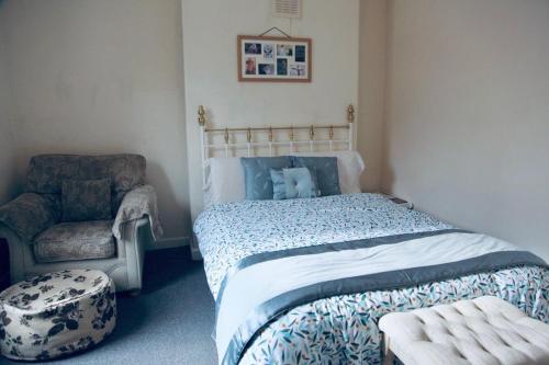 een slaapkamer met een bed en een stoel bij PEACEFULLY AND CENTRALLY LOCATED DOUBLE BEDROOM in Hunslet