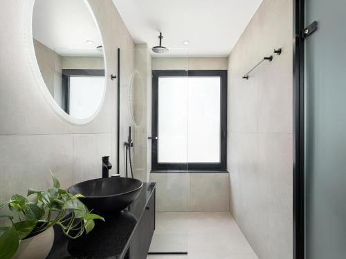 a bathroom with a black sink and a mirror at Theta Boutique Hotel in Chania