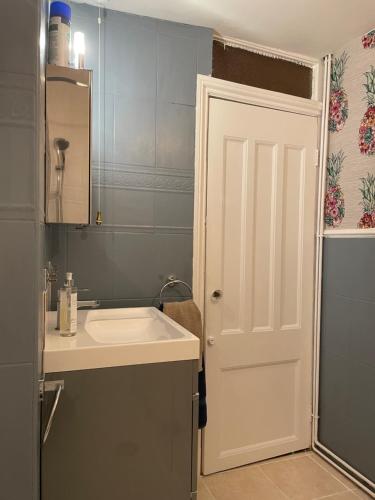 a bathroom with a sink and a white door at The Therapy Rooms Holmfirth Holiday Let in Holmfirth