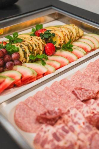 a buffet of food with fruit and meats on trays at Altstadt Hotel Stadtkrug in Salzburg