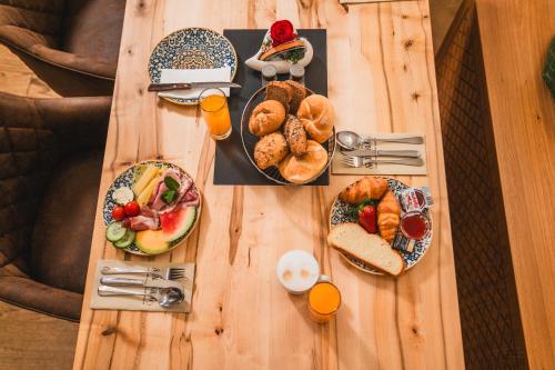 a wooden table topped with plates of breakfast foods at Altstadt Hotel Stadtkrug in Salzburg