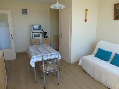 Cette chambre comprend une table, un lit et un four micro-ondes. dans l'établissement Le Voilier, à Saint-Jean-de-Monts