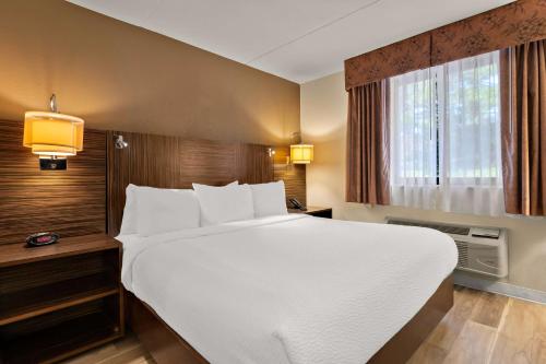 ein großes weißes Bett in einem Hotelzimmer in der Unterkunft Ramada by Wyndham Harrisburg/Hershey Area in Harrisburg