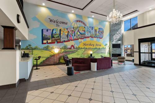 eine Lobby mit einem großen Wandbild in der Unterkunft Ramada by Wyndham Harrisburg/Hershey Area in Harrisburg