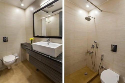 a bathroom with a sink and a toilet and a mirror at Hotel Majestic JPM - East Of Kailash in New Delhi