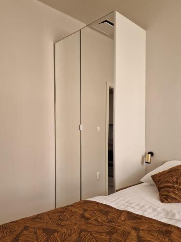 a bedroom with a large mirrored cabinet next to a bed at Old Town Apartment in Omiš