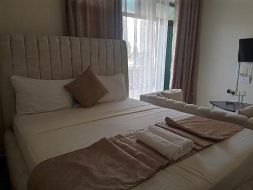 a bedroom with a large white bed with a window at Tamara Studio Apartment in Shanzu in Mtwapa