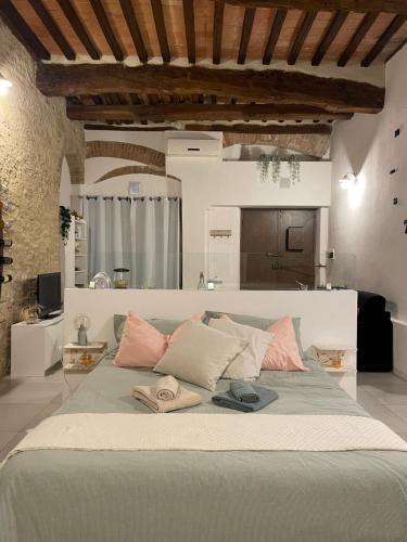 ein Schlafzimmer mit einem großen Bett mit rosa und weißen Kissen in der Unterkunft I Fiori di Colle, l’anima Toscana “Loft” in Colle di Val d’Elsa