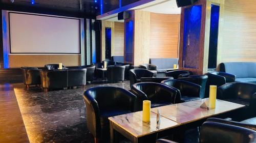 a room with chairs and tables and a projection screen at Royal Orchid Central Kireeti Hampi, Hospet in Hampi