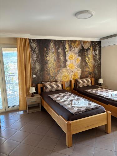 1 Schlafzimmer mit 2 Betten und einer Wand mit Blumen in der Unterkunft Apartmani "MARIJA" Golubac in Golubac