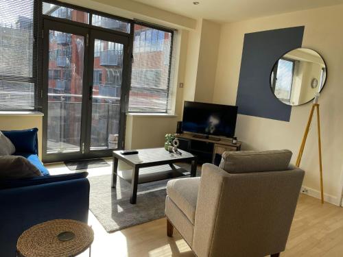 uma sala de estar com um sofá, uma cadeira e um espelho em Modern 2 BDR Flat in Nottingham City Centre with free parking em Nottingham