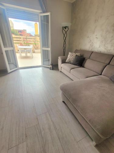 a living room with a couch and an open door at La casa di Fiona in Quartu SantʼElena