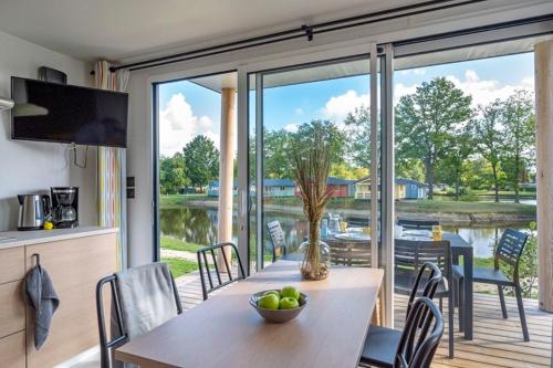 eine Küche und ein Esszimmer mit einem Tisch und einem großen Fenster in der Unterkunft Vakantiepark Vlinderloo in Enschede