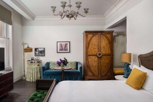 um quarto com uma cama, uma cadeira e uma mesa em The Beekman, A Thompson Hotel, by Hyatt em Nova York