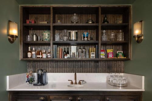 cocina con fregadero y estante con botellas en The Beekman, A Thompson Hotel, by Hyatt, en Nueva York