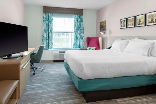 ein Hotelzimmer mit einem Bett und einem Flachbild-TV in der Unterkunft Hilton Garden Inn Ocala Downtown, Fl in Ocala