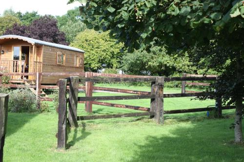 une clôture en bois devant une cabane en rondins dans l'établissement la Pomone, à Blonville-sur-Mer