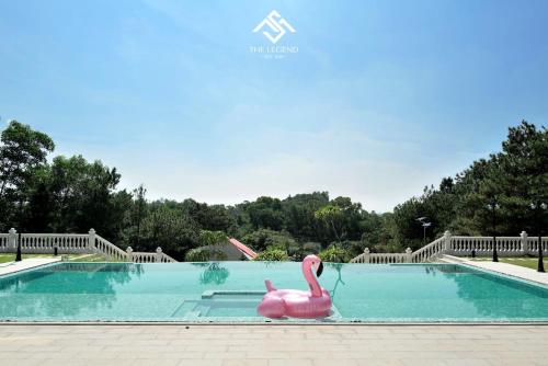 un flamenco rosa de plástico en una piscina en Villa The Legend Soc Son, en Hanói
