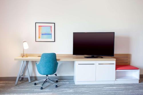 an office with a desk with a television and a chair at Hilton Garden Inn Broomfield Boulder in Broomfield