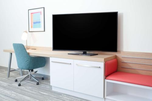 an office with a tv on a desk with a chair at Hilton Garden Inn Broomfield Boulder in Broomfield