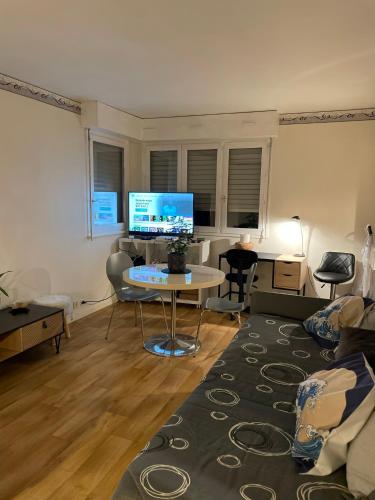 ein Wohnzimmer mit einem Sofa und einem Tisch mit einem Computer in der Unterkunft Manuezen studio très fonctionnel au calme in Vesoul