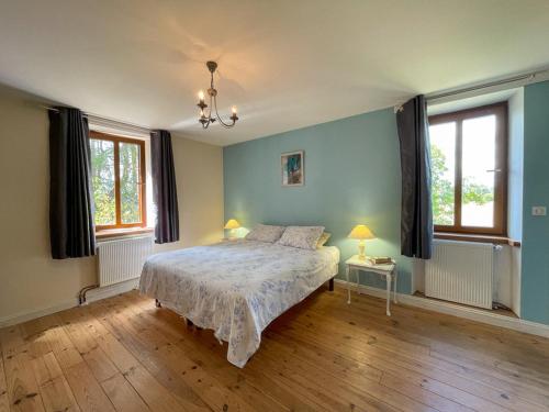 1 dormitorio con 1 cama con paredes y ventanas azules en La Maison des Hibiscus en Pagéas